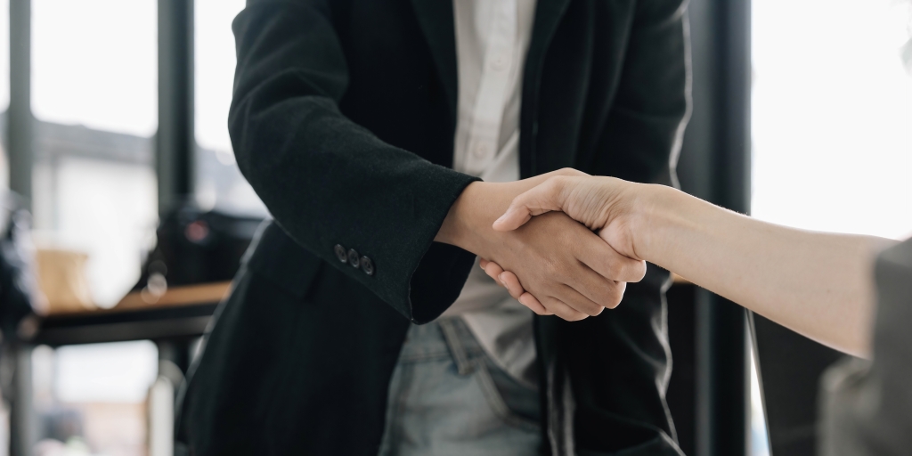 Two people shaking hands after finishing up a meeting