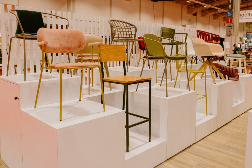 Tarrison's tradeshow booth with different styles of chairs being displayed on white risers