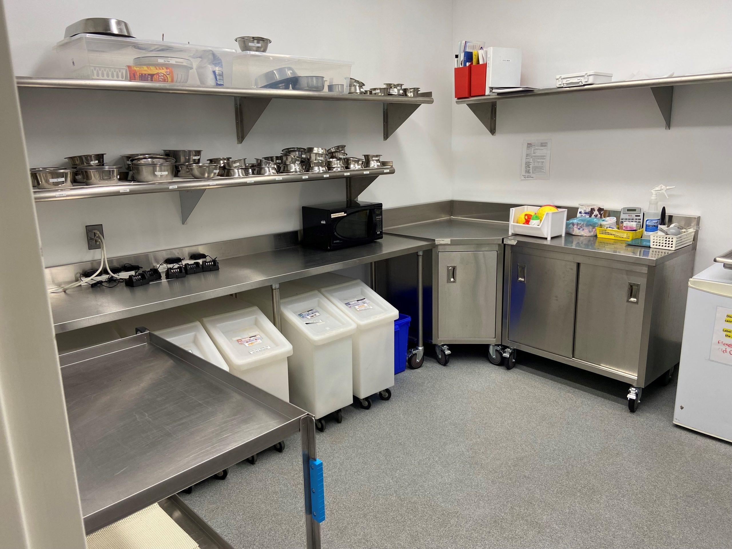 stainless steel cabinets with a corner cabinet and wall mounted shelves over top